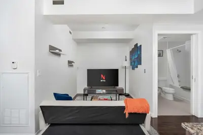 a living room with a couch and a tv at Stylish Condo with Private Patio in Fortyork in Toronto