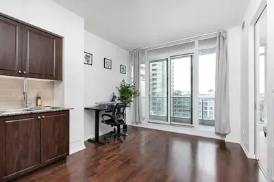 an empty kitchen with a desk and a window at Stylish Condo with Private Patio in Fortyork in Toronto