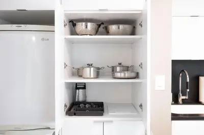 a kitchen with white shelves with pots and pans at Spacious Toronto Condo w Patio - City Comfort in Toronto