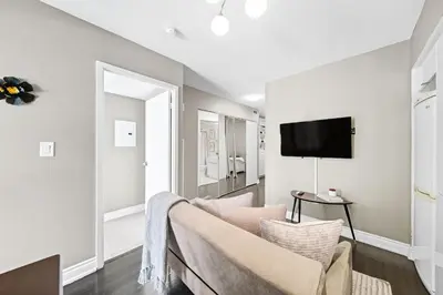 a living room with a couch and a flat screen tv at Spacious Toronto Condo w Patio - City Comfort in Toronto