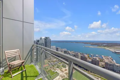 a chair sitting on top of a balcony with a view of a city at Sky-High Penthouse Breathtaking City Views in Toronto