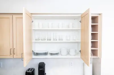 a kitchen cabinet with cups and plates in it at Downtown Toronto Studio Retreat in Toronto