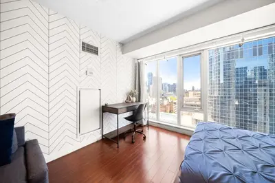 a bedroom with a desk and a large window at Downtown Toronto Studio Retreat in Toronto
