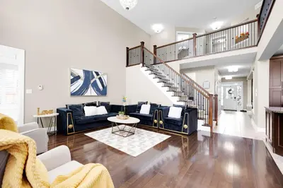 a living room with blue couches and a staircase at Pool, King Bed, Patio with BBQ, Fall Hiking Nearby in Cambridge
