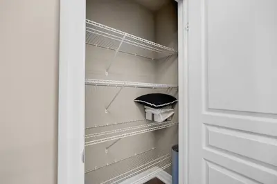 a walk in closet with white shelves and a door at Pool, King Bed, Patio with BBQ, Fall Hiking Nearby in Cambridge