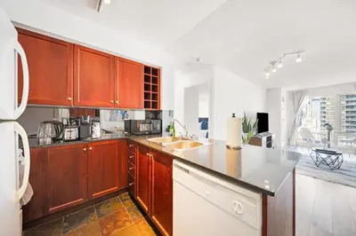 a kitchen with wooden cabinets and a white refrigerator at Chic 1BR Downtown Getaway w King Bed in Toronto