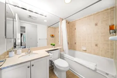 a bathroom with a toilet and a sink and a bath tub at Chic 1BR Downtown Getaway w King Bed in Toronto