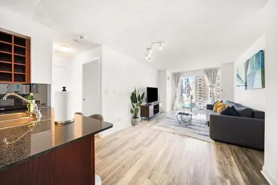 a kitchen and living room with a couch and a table at Chic 1BR Downtown Getaway w King Bed in Toronto