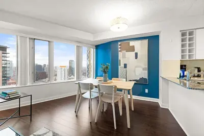 a kitchen and dining room with blue walls and a table and chairs at Yonge and Dun condo in Toronto