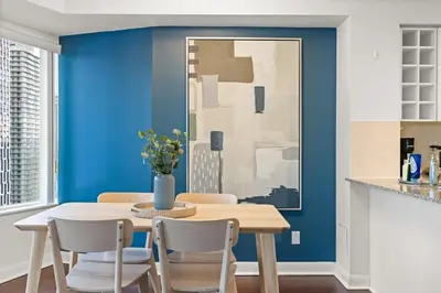 a dining room with blue walls and a table and chairs at Yonge and Dun condo in Toronto
