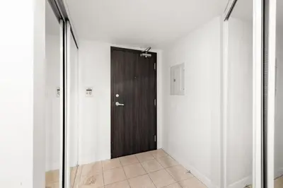 a hallway with a black door and white walls at Yonge and Dun condo in Toronto