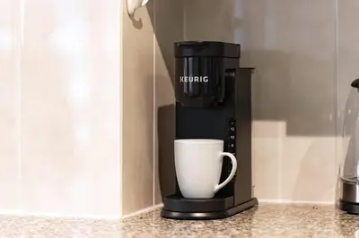a coffee maker with a cup on a counter at Yonge and Dun condo in Toronto