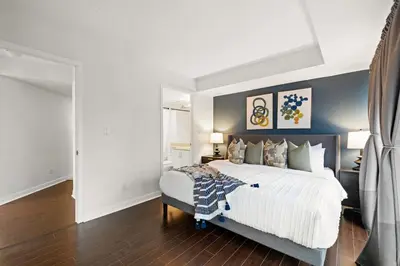 a bedroom with a large bed with white sheets and pillows at Yonge and Dun condo in Toronto