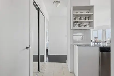 a white kitchen with a counter and a window at Stylish 2BR Downtown Escape Prime Victoria Spot in Toronto