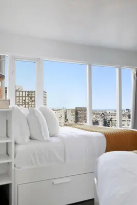 a white bedroom with a white bed and windows at Stylish 2BR Downtown Escape Prime Victoria Spot in Toronto