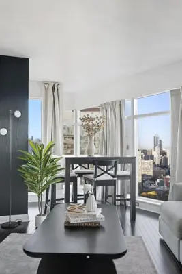 a living room with a table and a large window at Stylish 2BR Downtown Escape Prime Victoria Spot in Toronto