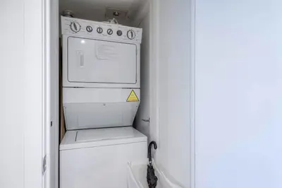 a white washer and dryer in a small kitchen at Modern 2 Bedroom plus Den Condo with Balcony Downtown Toronto in Toronto