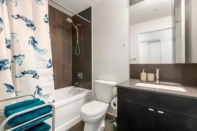 a bathroom with a toilet and a sink and a mirror at New Modern 2 Bedroom 2 Bath Apartment with Balcony in Toronto