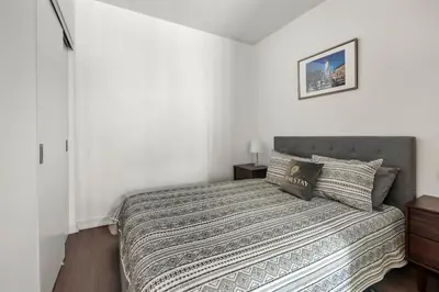 a bedroom with a bed with a striped comforter at New Modern 2 Bedroom 2 Bath Apartment with Balcony in Toronto