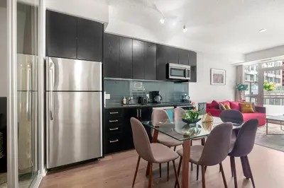 a kitchen and dining room with a table and a refrigerator at New Modern 2 Bedroom 2 Bath Apartment with Balcony in Toronto