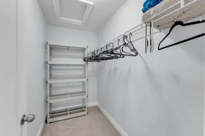 a walk in closet with white walls and white shelves at Chic Open-Concept 5 Beds Home by Airport and Highways in Brampton