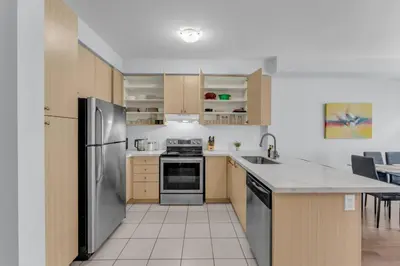 a kitchen with a stainless steel refrigerator and cabinets at Chic Open-Concept 5 Beds Home by Airport and Highways in Brampton