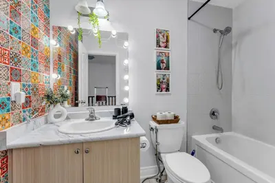 a bathroom with a toilet and a sink and a tub at Chic Open-Concept 5 Beds Home by Airport and Highways in Brampton