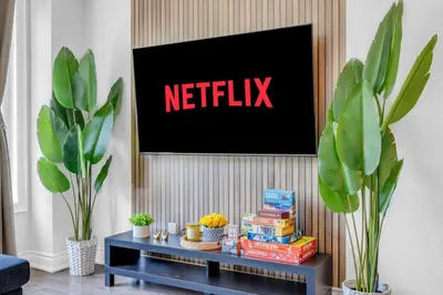 a living room with a netflix sign on a wall at Chic Open-Concept 5 Beds Home by Airport and Highways in Brampton