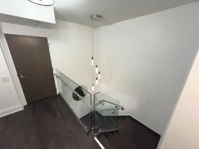 a staircase with a glass railing next to a door at Luxury 2-Story loft in downtown in Toronto