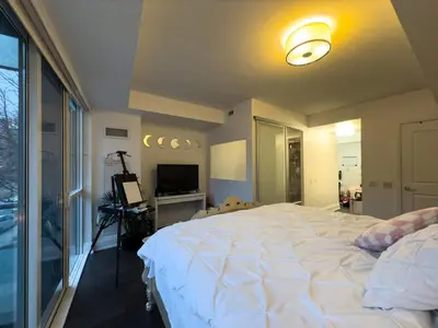 a bedroom with a large white bed and a television at Luxury 2-Story loft in downtown in Toronto
