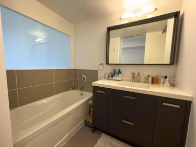 a bathroom with a tub and a sink and a mirror at Luxury 2-Story loft in downtown in Toronto