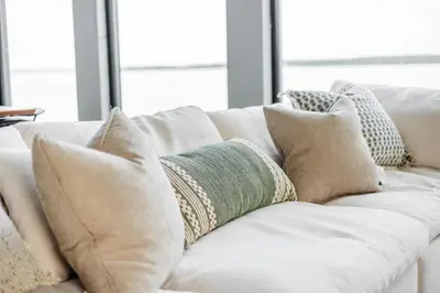 a white couch with many pillows on it at Casa Luna Chic Lakehouse BBQ Game Room LakeViews in Orillia