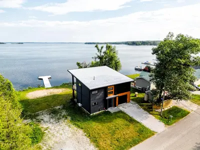 an aerial view of a tiny house on the shore of a lake at Casa Luna Chic Lakehouse BBQ Game Room LakeViews in Orillia