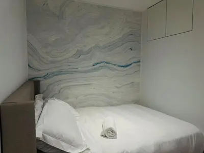 a bed in a room with a painting on the wall at Camden Haus Loft in Toronto