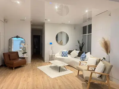 a living room with a white couch and a chair at Camden Haus Loft in Toronto