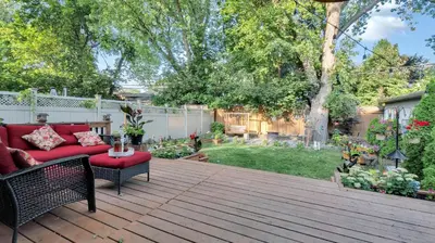 a patio with a red couch on a wooden deck at Cozy Luxurious Villa in Toronto in Toronto