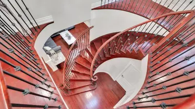 a spiral staircase with wooden railings in a house at Cozy Luxurious Villa in Toronto in Toronto