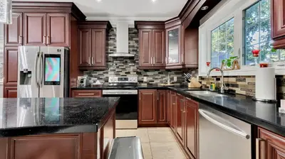 a large kitchen with wooden cabinets and black counter tops at Cozy Luxurious Villa in Toronto in Toronto