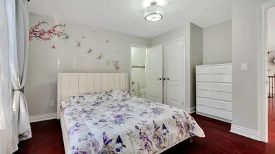 a bedroom with a bed with a floral bedspread at Cozy Luxurious Villa in Toronto in Toronto