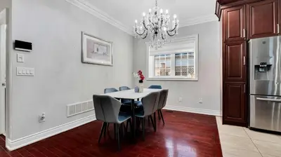a dining room with a table and chairs and a chandelier at Cozy Luxurious Villa in Toronto in Toronto