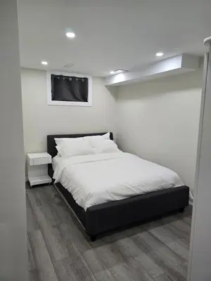 a bedroom with a bed and a tv on the wall at Charming Suite in Cambridge