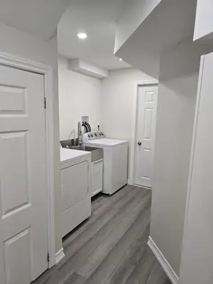 a white kitchen with a sink and a stove at Charming Suite in Cambridge