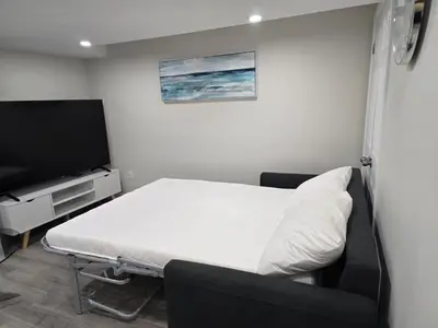 a hospital room with a bed and a flat screen tv at Charming Suite in Cambridge