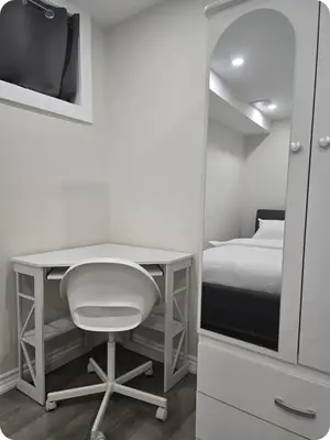 a bedroom with a desk and a bed and a television at Charming Suite in Cambridge