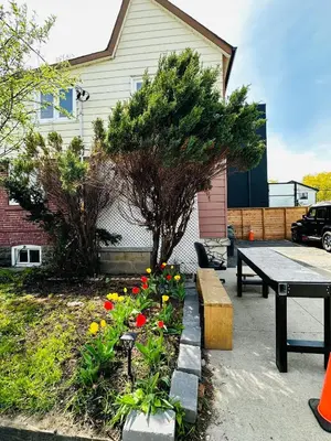 a picnic table and flowers in front of a house at Relax in East York Space Share in Toronto