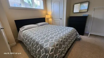 a bedroom with a bed and a mirror in it at Spacious 2 BR, 3 beds, sleeps 6, kitchen, laundry in Richmond Hill