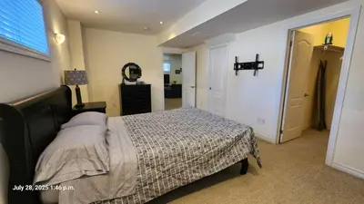 a bedroom with a bed and a dresser and a mirror at Spacious 2 BR, 3 beds, sleeps 6, kitchen, laundry in Richmond Hill