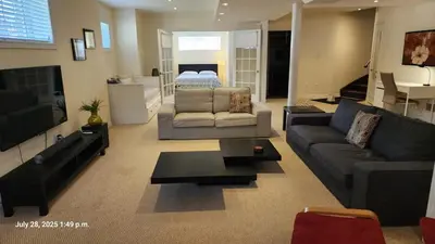 a large living room with a couch and a bed at Spacious 2 BR, 3 beds, sleeps 6, kitchen, laundry in Richmond Hill