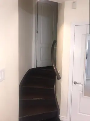 a staircase in a room with a door and a stair case at Spacious 2 BR, 3 beds, sleeps 6, kitchen, laundry in Richmond Hill