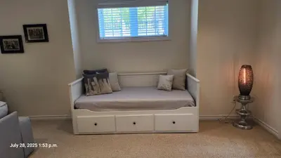 a bed in a room with a window and a lamp at Spacious 2 BR, 3 beds, sleeps 6, kitchen, laundry in Richmond Hill